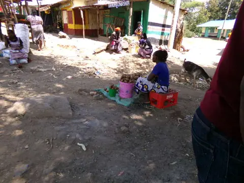 Traders sitting with their goods outside the shopfronts