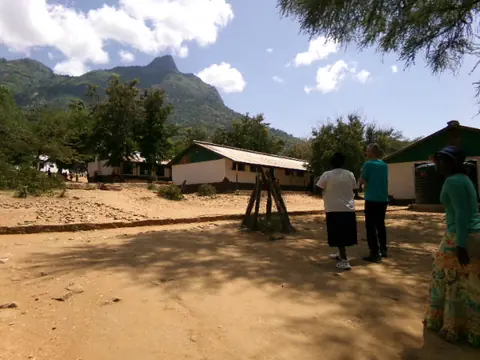 School buildings and swing frame against the ridge line