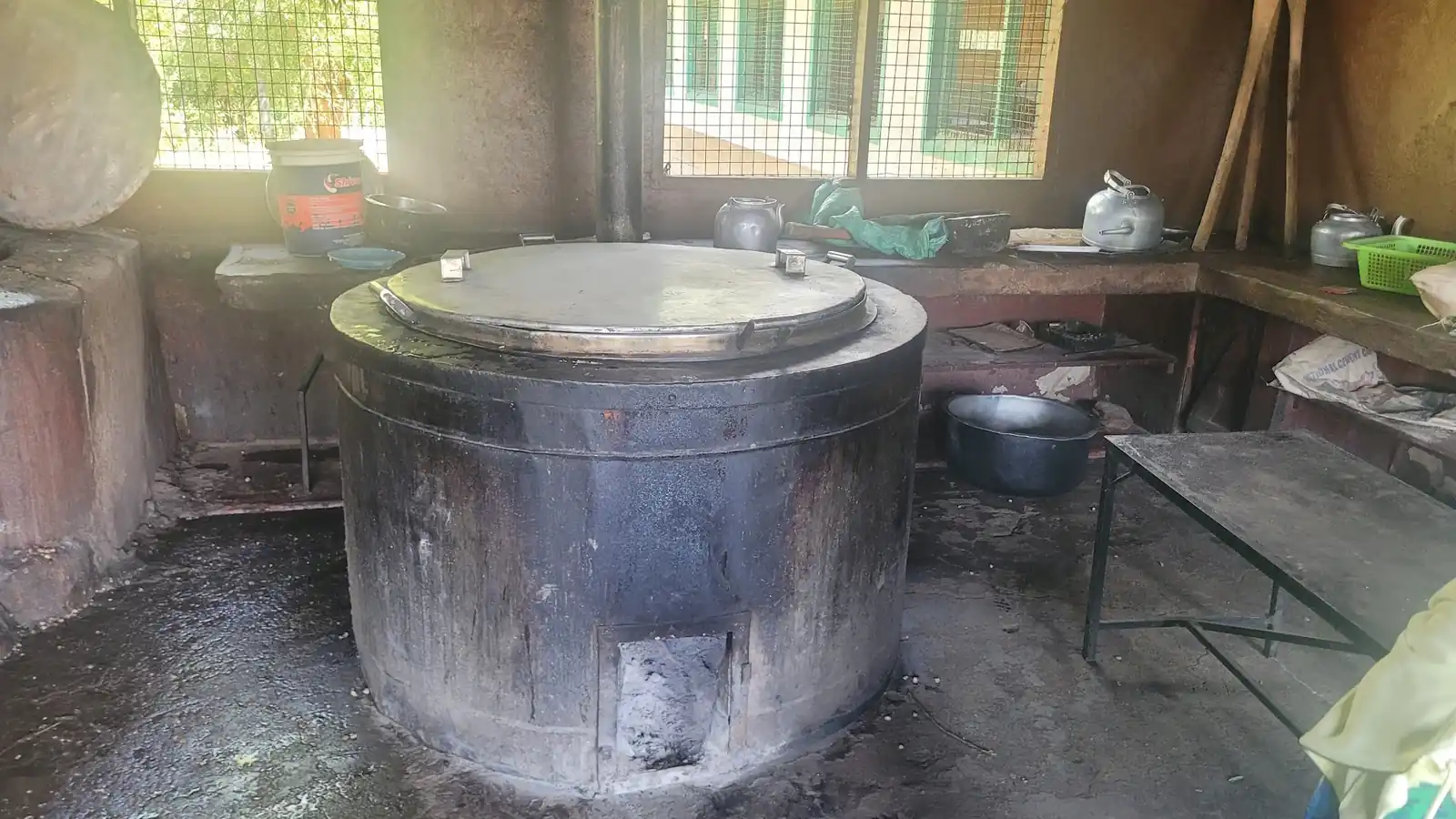 The school kitchen: cooking drums set over wood fires