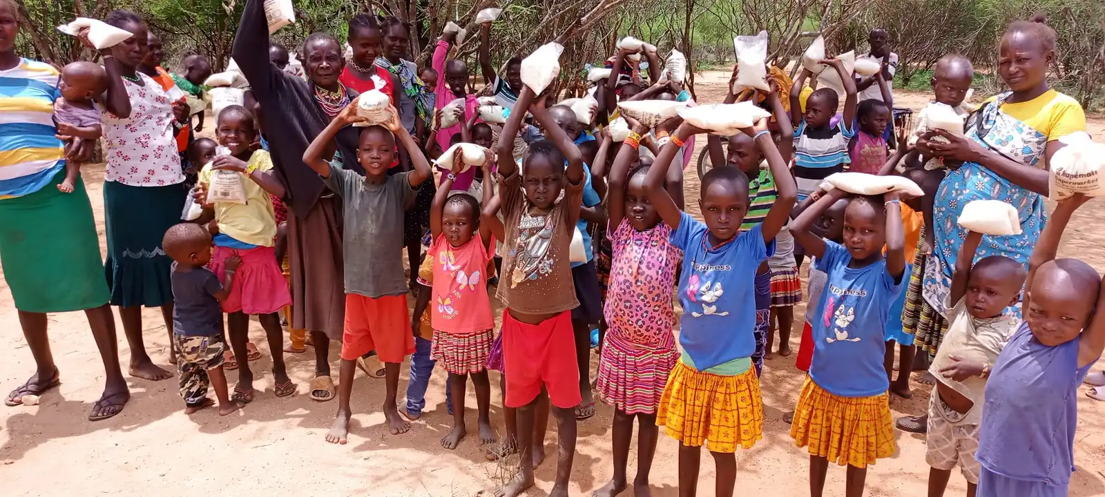 Children holding up bags of flour at a food distribution