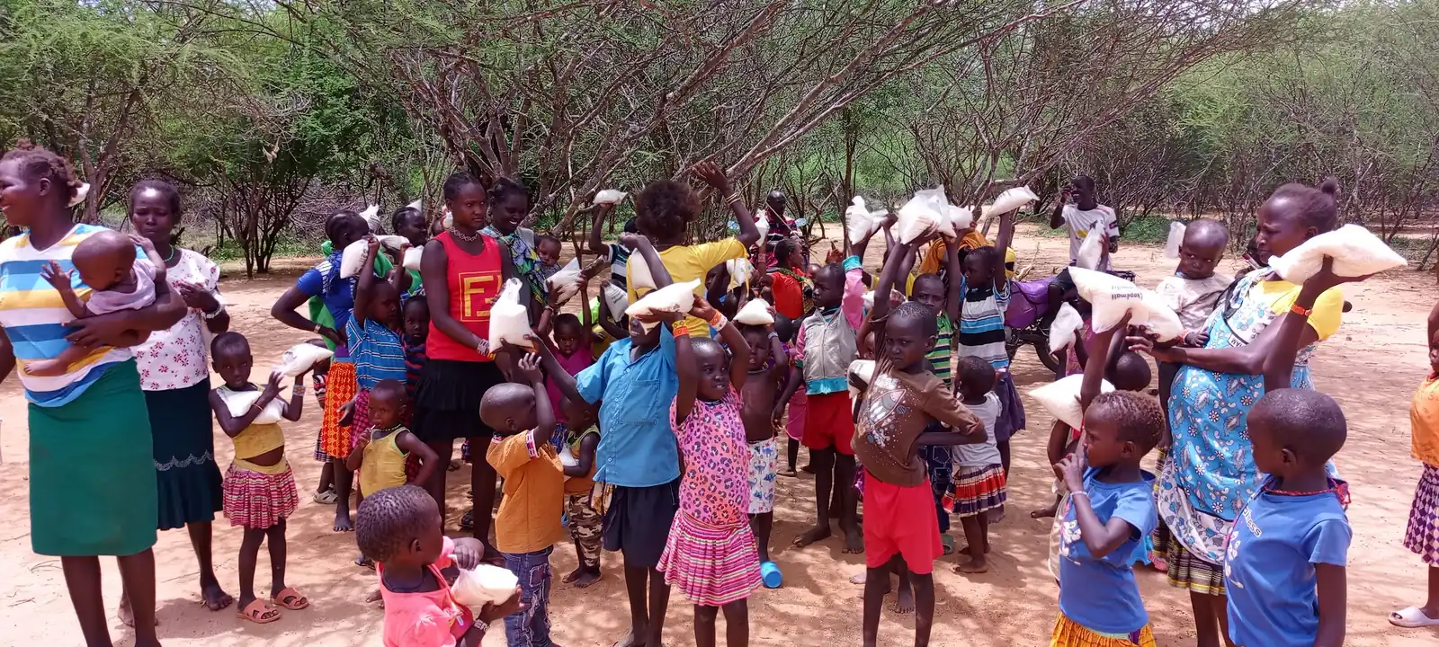 Mothers and children holding their share at a food distribution
