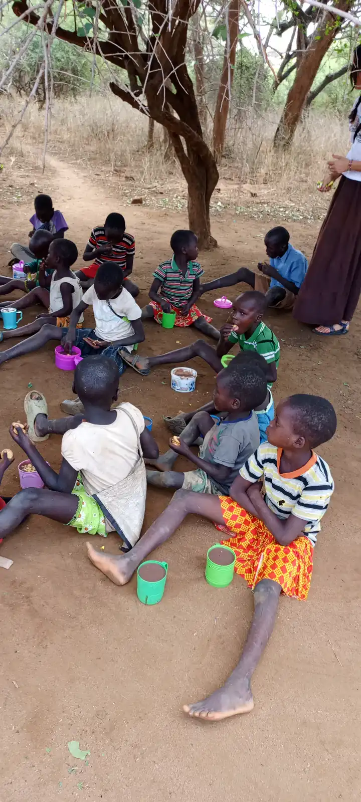 Eating a meal together on the ground under the trees